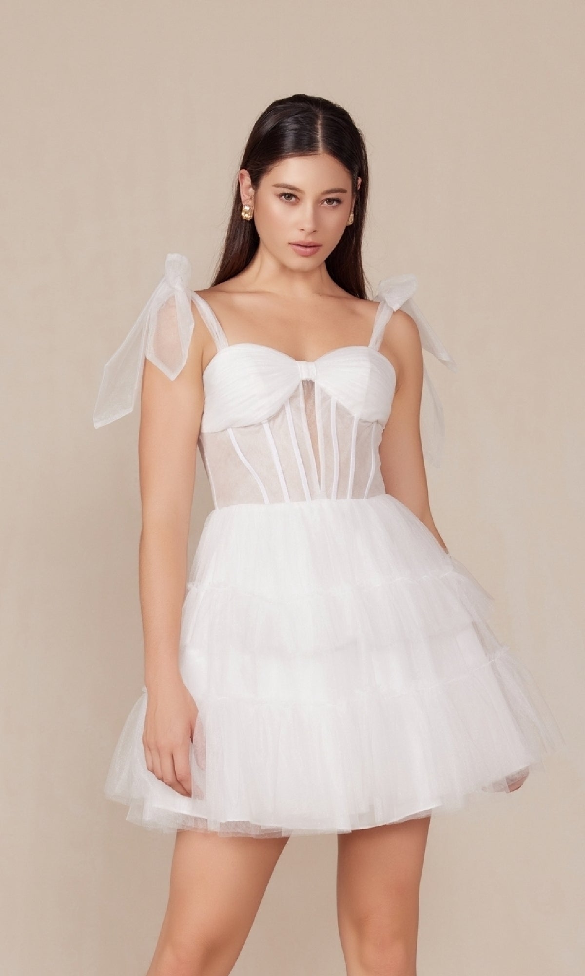 A woman models the Sheer-Bodice Short White A-Line Party Dress Y858W, featuring a fitted bodice, sheer panels, and ribbon shoulder straps, standing against a plain beige background.